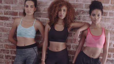 Fitness-women-standing-against-brick-wall-in-gym