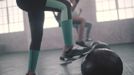 Frauen,-die-Übung-mit-Medizinball-im-Fitness-Studio