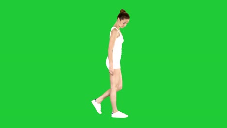 Young-woman-in-sportswear-taking-a-walk-looking-down-on-a-Green-Screen,-Chroma-Key