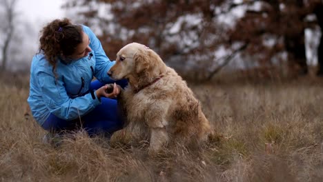 Cheerful-woman-caressing-her-labrador-retriever