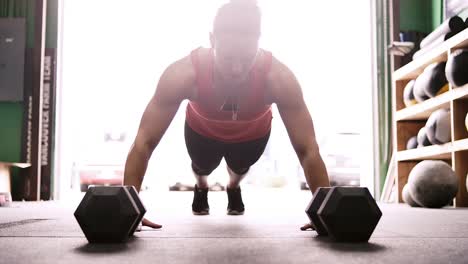 A-fit-young-woman-doing-pushups-and-listening-to-music-and-then-looking-at-the-camera