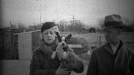 1933:-Couple-showing-off-new-small-dog-in-formal-winter-clothing.