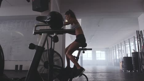 Fit-young-woman-using-exercise-bike-at-the-gym