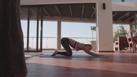 Fitness-woman-doing-stretching-in-living-room