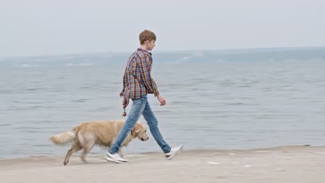 Teenage-Boy-Walking-Dog-am-Strand