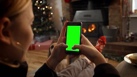 Woman-On-Line-With-Mobile-Phone-In-Room-Ready-For-Christmas