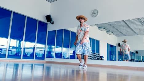 Hombre-gracioso-en-gafas-de-sol-y-sombrero-bailando-en-el-gimnasio