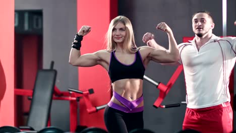 joven-pareja-deportiva-mostrando-músculo-y-entrenamiento-en-gimnasio