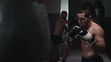 Zwei-Athleten-zu-bekämpfen-Training-mit-Punch-Taschen