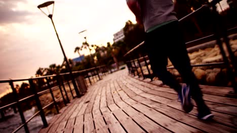 Young-athletic-man-running-next-to-the-sea-at-sunset