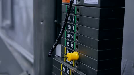 Close-up-shot-of-woman's-hand-and-stacks-of-weight-plates