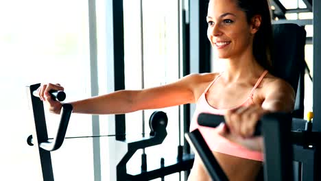 Young-attractive-woman-doing-exercises-in-gym