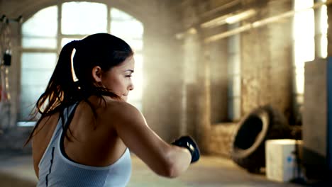 Hermosa-mujer-atlética-aire-de-golpes-con-sus-puños-como-parte-de-su-intensivo-entrenamiento-gimnasio-Cross.