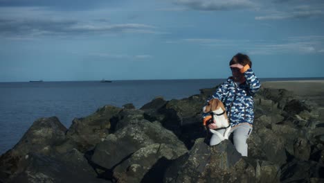 4K-Outdoor-Seaside-Child-and-Dog-Posing-on-Rocks