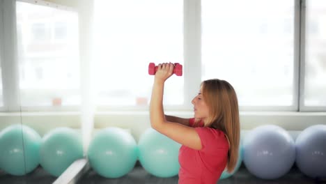 Übungen-mit-Hanteln-für-die-Hände.-Frauen-engagieren-sich-im-Sport-in-der-Turnhalle