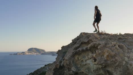 Running-man-arrives-on-top-of-a-cliff-on-an-island-in-front-of-the-ocean