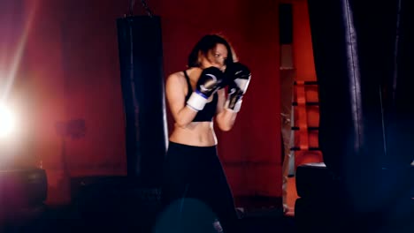 A-young-female-boxer-starts-beating-at-a-punching-bag.