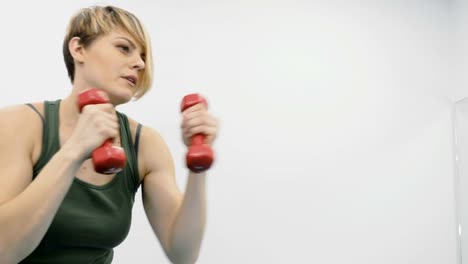 Mujer-entrenamiento-brazos-con-pesas-e-imita-movimientos-de-boxeo