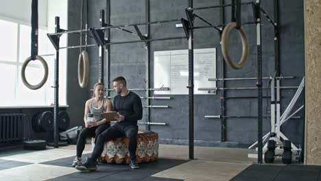 Woman-Listening-Instructions-of-Male-Coach-in-Cross-Training-Gym