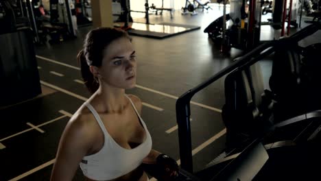 Attractive-fitness-woman-walking-on-treadmill-for-cardio-training-in-gym-club