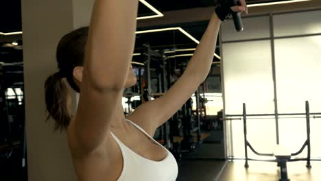 Sexy-woman-lifting-weights-from-above-for-training-muscle-back-in-fitness-club