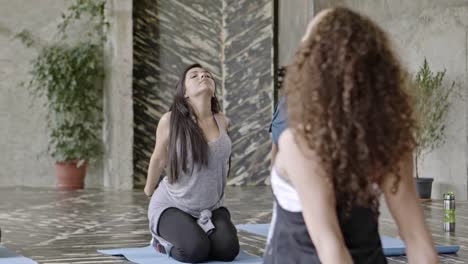 Mujeres-que-se-extiende-en-clase-de-Yoga