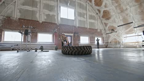 Woman-Doing-Sledgehammer-Exercise-with-Tire