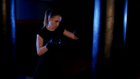 Girl-is-boxing.-Beautiful-kickboxing-woman-training-punching-bag.-Fighter-woman-fist-close-up.