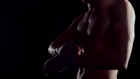 Male-boxer-wraps-his-hands-with-handwrap.-professional-boxer-wrapping-bandages-on-his-hand.-Fighter-wrapping-hands-with-boxing-wraps-in-the-gym