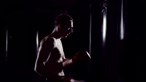 Boxer-Boxsack.-Slow-Motion-Sequenz.-Starke-Sportler-trifft-einen-Boxsack.-Kickboxen-Männer-training-Boxsack-im-Fitness-Studio.-Kämpfer-Training-Slow-Motion