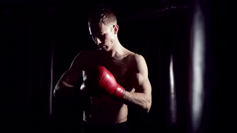 Boxeador-se-pone-guantes-de-boxeo.-Hombre-luchador-poniendo-los-guantes,-en-cámara-lenta.-Kickboxer-preparándose-poner-guantes-de-tren