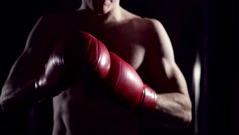 Boxeador-se-pone-guantes-de-boxeo.-Hombre-luchador-poniendo-los-guantes,-en-cámara-lenta.-Kickboxer-preparándose-poner-guantes-de-tren