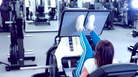 Adult-woman-makes-a-аoot-press-in-the-simulator.-Fitness-girl-workout-with-simulator-leg-press-at-gym