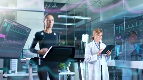 Woman-Athlete-Runs-on-a-Treadmill--with-Electrodes-Attached-to-Her-Body-while-Scientist-Holding-Tablet-Computer-Supervises-whole-Process.-In-the-Background-Laboratory-with-Monitors-Showing-EKG-Readings.