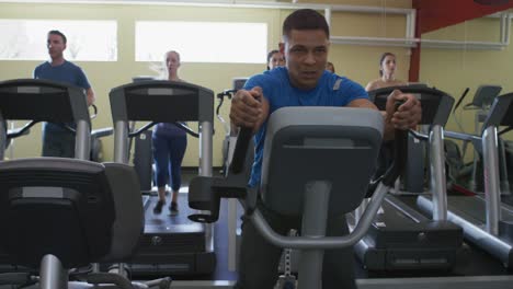 Man-working-out-hard-on-stair-machine-at-gym