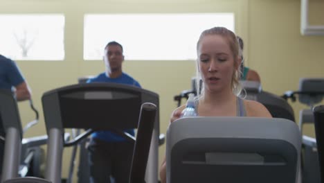 Woman-taking-drink-of-water-at-gym