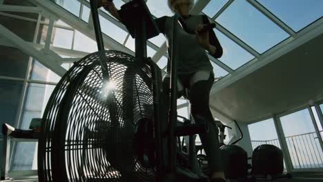 Elderly-Woman-on-Cycling-Machine-in-Gym