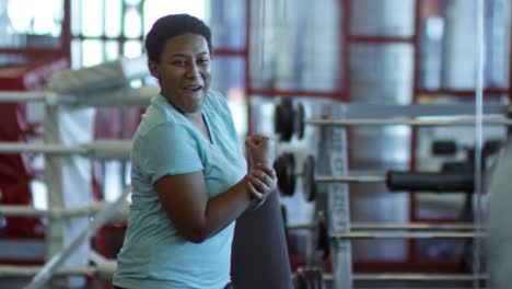 Negro-mujer-doblando-en-gimnasio-y-riendo