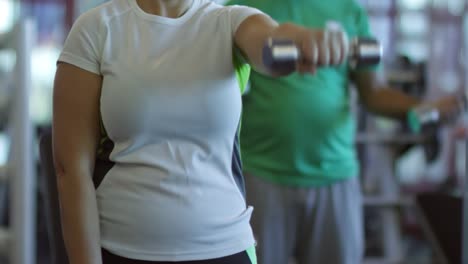 Woman-Looking-in-Mirror-and-Exercising-with-Dumbbells