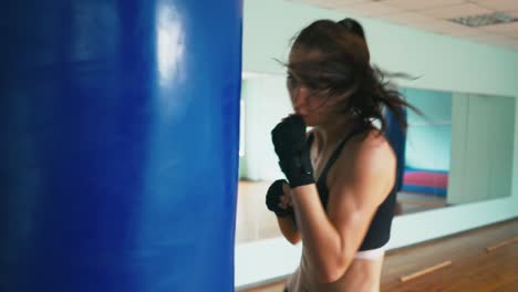 Schöne-gemischte-Rennen-Kickboxen-Frau-Training-Boxsack-im-Fitness-Studio-heftige-Stärke-passen-Körper-Kickboxer-Serie