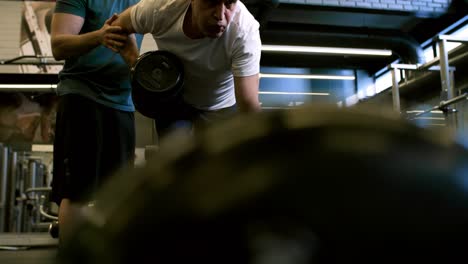 Man-Performing-Dumbbell-Rows-in-Gym