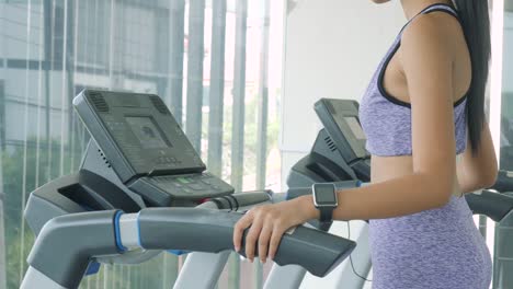 Asian-girl-running-on-the-treadmill-in-the-gym