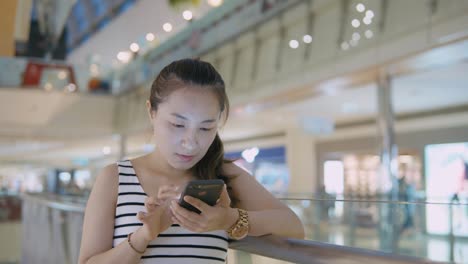 Woman-using-mobile-phone-in-the-mall