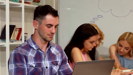 Cheerful-young-man-smiling-joyfully-while-working-on-his-laptop