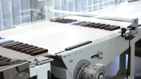 Ready-chocolates-on-the-production-line-at-chocolate-factory-Manufacturing-line-of-chocolate-candy-Sweet-food-on-production-line-Desserts-moving-on-conveyor-belt-4K