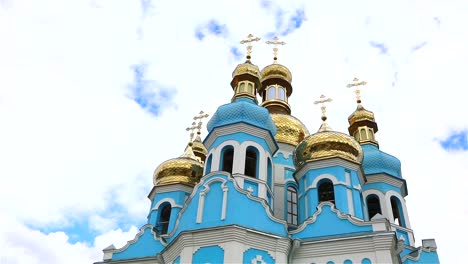 Orthodox-temple,-Clouds-above-the-temple,-golden-domes,-Timelapse,-exterior,-a-view-from-below,-Blue-temple,-blue-church,-Against-the-sky,-Golden-domes