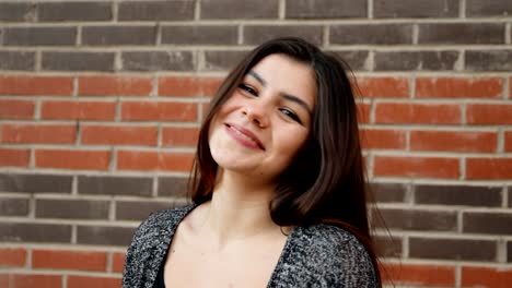 Slow-motion-portrait-of-a-young-attractive-woman-looks-with-a-serious-look-then-smiles.