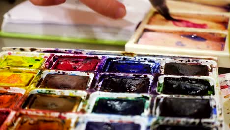 artist-blending-watercolors-on-a-palette-with-the-brush