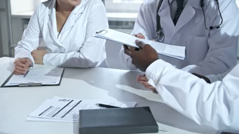 Doctors-Discussing-Documents-and-Shaking-Hands