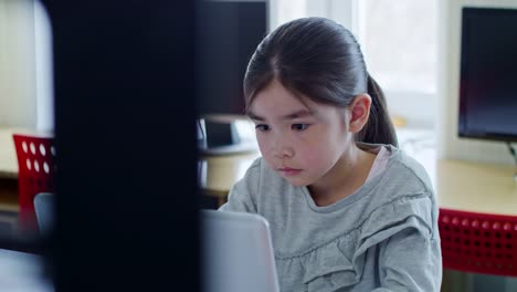 Concentrated-Schoolgirl-Working-with-Laptop-Computer